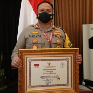 Kapolres Malang AKBP Hendri Umar saat menerima penghargaan. (Foto: Humas Polres Malang/Tugu Jatim)