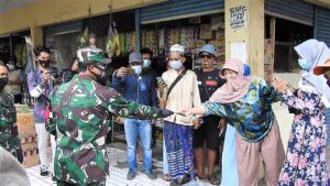 Bagi-bagi masker oleh anggota Kodim 0819 Pasuruan di Pasar Kebon Agung dan Pasar Warungdowo, Sabtu (6/2/2021). (Foto: Dokumen) tugu jatim
