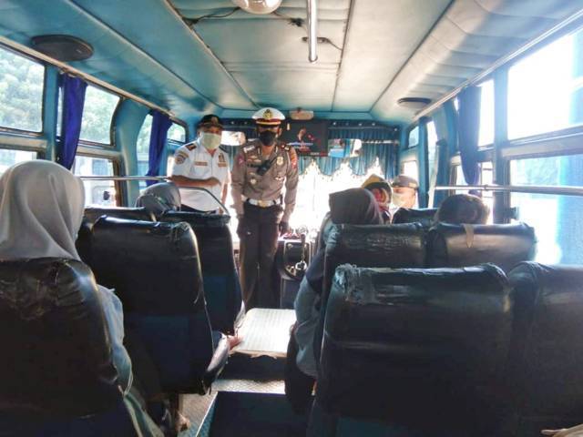 AKP Rizal Nugra Wijaya mengimbau kepada penumpang bus agar tetap jaga jarak dan melaksanakan protokol kesehatan. (Foto: Mila Arinda/Tugu Jatim)