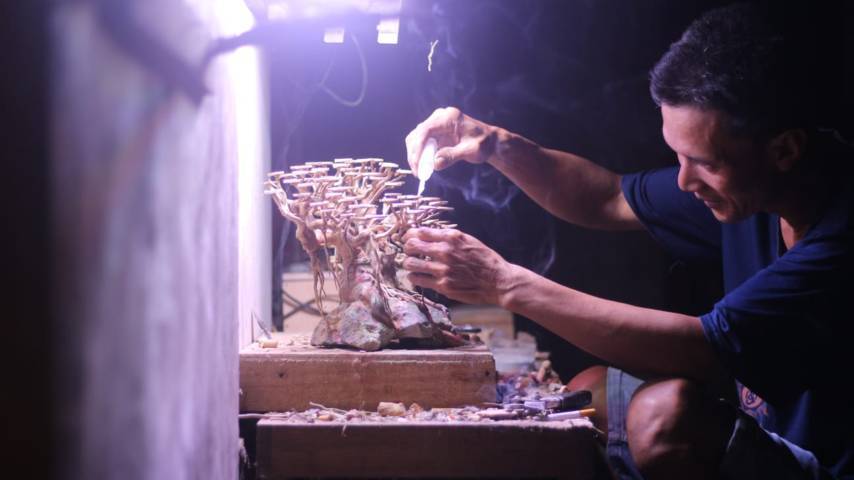 Nanang Subandi tampak konsentrasi untuk membuat bonsai aquatic-nya. (Foto: Zamzuri/Tugu Jatim)