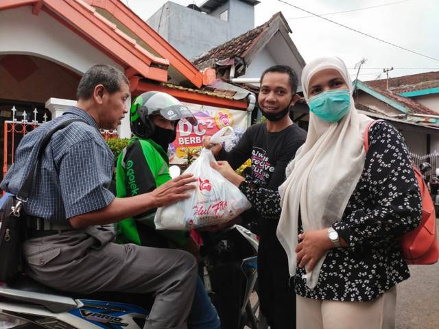 Istri dr Tandya, Aminah Najmah memberikan paket sembako kepada salah satu difabel tunanetra, Jumat (7/5/2021). (Foto: Dokumen/Tugu Jatim)