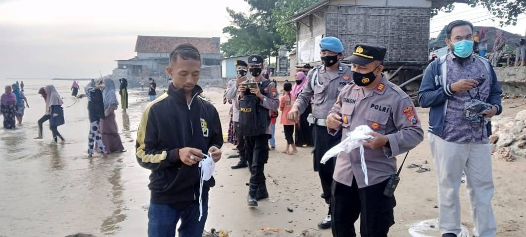 Ingin mencegah persebaran Covid-19, petugas Polsek Palang membagikan 300 masker kepada warga. (Foto: Rochim/Tugu Jatim)