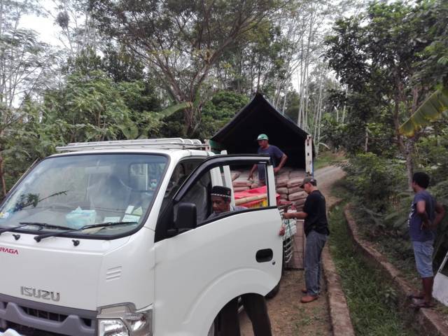 Material bangunan dari Tugu Media Peduli X Bakti BCA dimuat ke mobil buah milik warga. (Foto: Dicky Hanafi/Tugu Jatim)