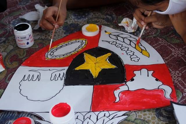 Simbol sila-sila yang berada di dada burung garuda di lambang Garuda Pancasila tengah dilukis dan diwarnai satu-satu oleh anak-anak dari Desa Gadungan, Kediri. (Foto: Rino Hayyu/Tugu Jatim)