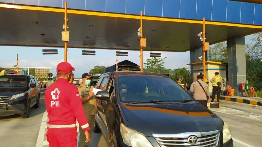 Petugas penyekatan PPKM Darurat di Exit Tol Singosari Malang, mengecek surat kelengkapan dari para pengendara. (Foto:Azmy/Tugu Jatim)