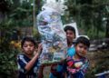 anak-anak membawa sampah. Menengok Gubuk Baca Lereng Busu: Kala Sekolah Cukup Dibayar dengan Sampah