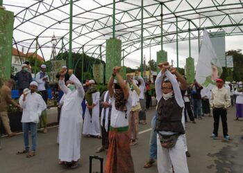Massa aksi Muslim Malang Bersatu mengepalkan tangan terborgol sebagai aksi solidaritas menuntut pembebasan Habib Rizieq, Jumat (18/12). (Foto: Azm/Tugu Malang/Tugu Jatim)