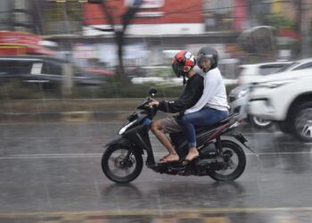Pengendara motor menerbos hujan. Tips menjaga kesehatan.