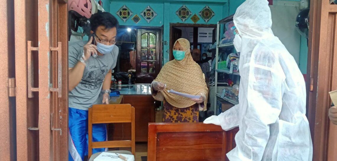 Meski Suspect Corona, Warga di Malang Tetap Gunakan Hak Pilih 1 Petugas KPPS keliling mengantarkan surat suara di rumah pasien isolasi mandiri di Kabupaten Malang, Rabu (9/12). (Foto: Azm/Tugu Jatim)