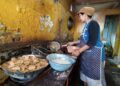Salah satu perajin tempe tengah memproduksi keripik. (Foto: Azm/Tugu Malang/Tugu Jatim)