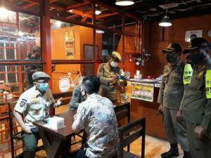 Petugas satpol PP memproses penyegelan di salah satu kafe di Malang. (Foto: Azmy) 