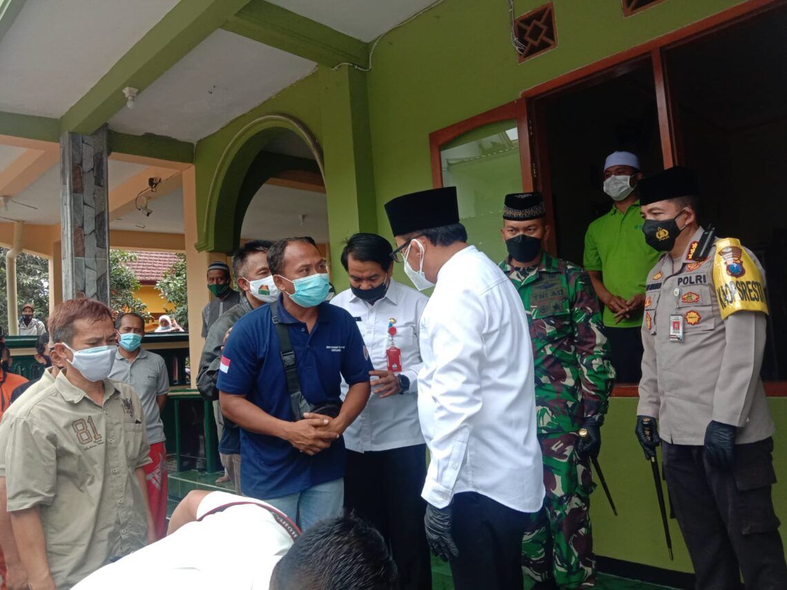 Hanyut Sejauh 26 Km, Korban Longsor di Malang Ditemukan di Bendungan Sengguruh Kepanjen 1 Wali Kota Malang Sutiaji sedang berkoordinasi dengan keluarga Roland Sumarna, korban plengsengan ambrol di Kota Malang, saat persiapan pemakaman jenazah. (Foto: Feni Yusnia/Tugu Malang)