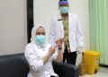 Bupati Bojonegoro Anna Muawanah agar tak terpapar Covid-19 mengikuti kegiatan vaksinasi. Dia juga menunjukkan vaksin sinovac yang akan disuntikkan. (Foto: Mila Arinda/Tugu Jatim)