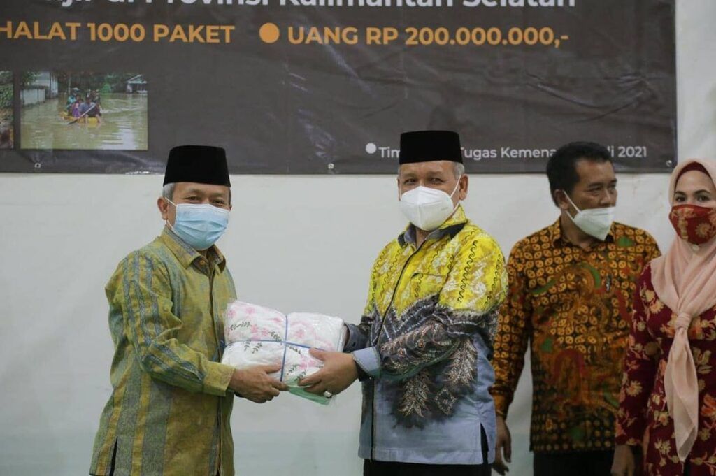 Sekjen Kemenag RI Nizar Ali (kanan) menyerahkan bantuan untuk warga terdampak banjir kepada Kakanwil Kemenag Kalimantan Selatan Noor Fahmi (kiri). (Foto:Humas Kemenag RI/Tugu Jatim)