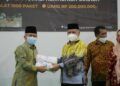 Sekjen Kemenag RI Nizar Ali (kanan) menyerahkan bantuan untuk warga terdampak banjir kepada Kakanwil Kemenag Kalimantan Selatan Noor Fahmi (kiri). (Foto:Humas Kemenag RI/Tugu Jatim)