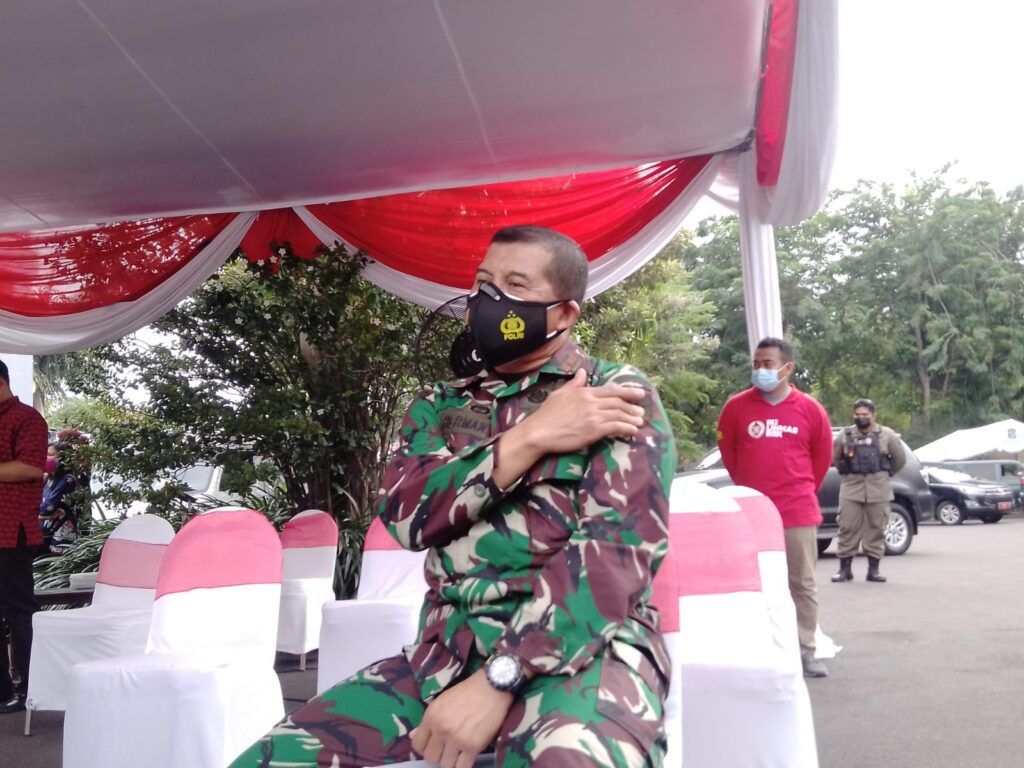 Danrem) 084 Bhaskara Jaya, Brigjen TNI Herman Hidayat Eko Atmojo memegang lengan kirinya usai vaksinasi COVID-19, Jumat (15/1/2021). (Foto: Rangga Aji/Tugu Jatim)