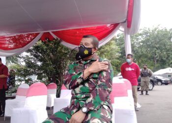 Danrem) 084 Bhaskara Jaya, Brigjen TNI Herman Hidayat Eko Atmojo memegang lengan kirinya usai vaksinasi COVID-19, Jumat (15/1/2021). (Foto: Rangga Aji/Tugu Jatim)