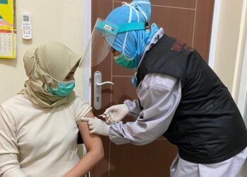 Salah satu tenaga kesehatan (nakes) bernama Nita Legiantini Purnama Sari sedang divaksin Sinovac di Puskesmas Ngagel Rejo Surabaya. (Foto: Pemkot Surabaya) tugu jatim