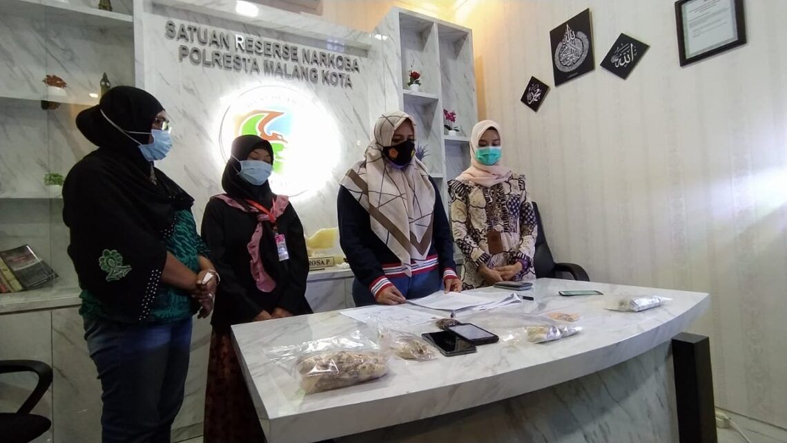 Temuan Tembakau Dalam Mendol di Lapas Malang Terbukti Bukan Narkotika 1 Kasatreskoba Polresta Malang Kota, Kompol Anria Rosa Piliang bersama pengirim paket tembakau yang diduga narkotika, Sabtu (30/1/2021). (Foto: Azmy/Tugu Malang/Tugu Jatim)