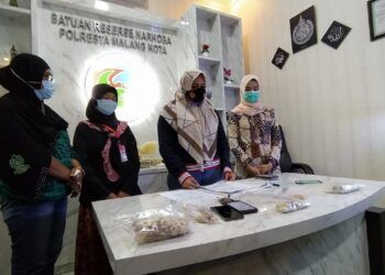 Kasatreskoba Polresta Malang Kota, Kompol Anria Rosa Piliang bersama pengirim paket tembakau yang diduga narkotika, Sabtu (30/1/2021). (Foto: Azmy/Tugu Malang/Tugu Jatim)