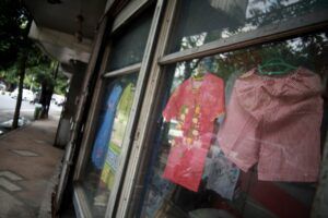 Beberapa pakaian tampak dipajang di depan Toko Riang yang terlihat dari balik kaca. (Foto: BEN/Tugu Malang/Tugu Jatim)
