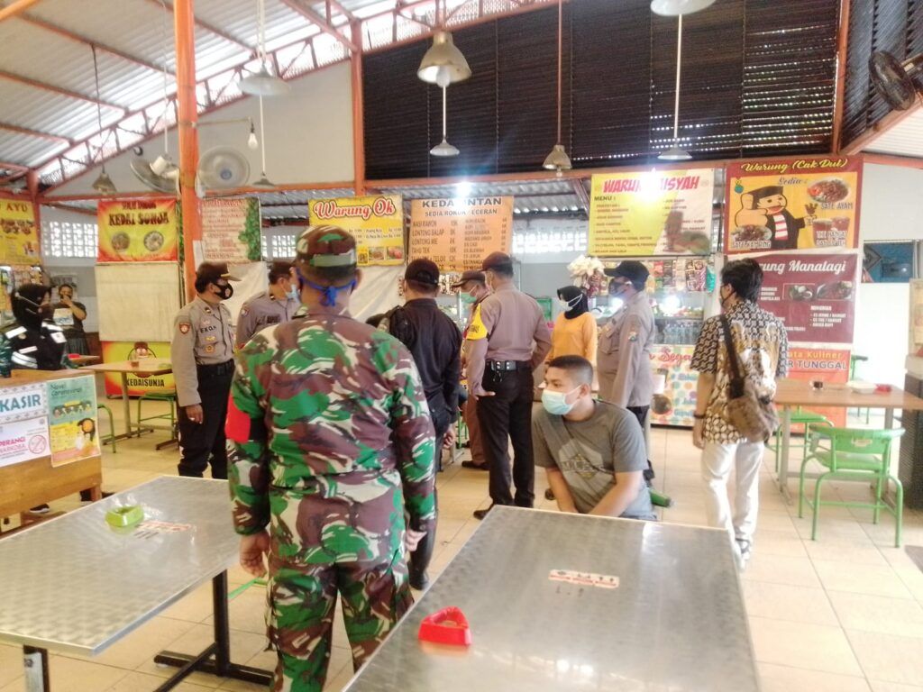 Tim Gabungan dari tiga pilar meliputi Kecamatan Wiyung, Polsek Wiyung, Koramil Wiyung, Satpol-PP Wiyung dan jajaran melakukan inspeksi mendadak (sidak) operasi yustisi di Sentra Kuliner Jajartunggal, Surabaya, Jumat (05/02/2021), pukul 10.00 WIB. (Foto: Rangga Aji/Tugu Jatim)