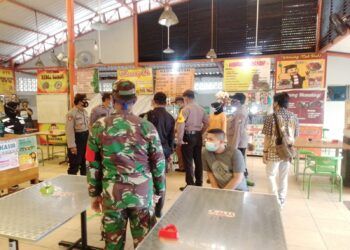 Tim Gabungan dari tiga pilar meliputi Kecamatan Wiyung, Polsek Wiyung, Koramil Wiyung, Satpol-PP Wiyung dan jajaran melakukan inspeksi mendadak (sidak) operasi yustisi di Sentra Kuliner Jajartunggal, Surabaya, Jumat (05/02/2021), pukul 10.00 WIB. (Foto: Rangga Aji/Tugu Jatim)