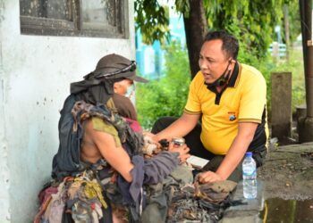 Aipda Purnomo membujuk ODGJ di Lamongan agar mau pakaiannya yang terbuat dari puluhan potongan kain itu diganti. (Foto: Dok Aipda Purnomo/Mila Arinda/Tugu Jatim)