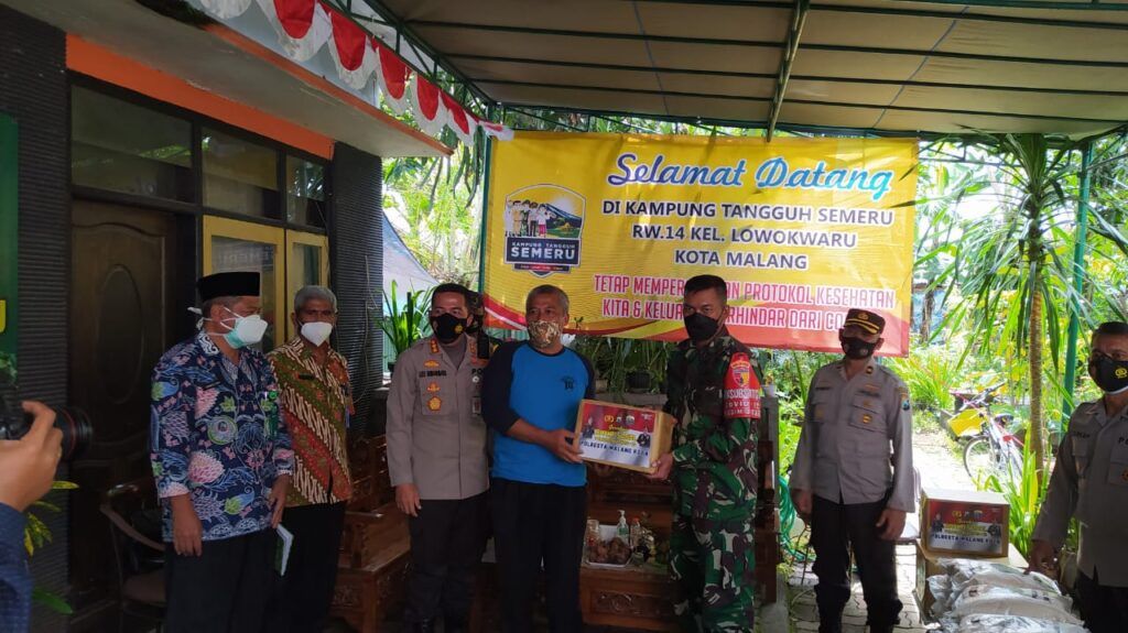 Kapolresta Malang Kota Kombes Pol Leonardus Simarmata saat memberikan bantuan masker dan kebutuhan pangan kepada Kampung Tangguh, RW 14, Kelurahan Lowokwaru, untuk meminimalisasi penyebaran Covid-19, yang diwakili Joko Widodo, Jumat (05/02/2021). (Foto: Azmy/Tugu Jatim)