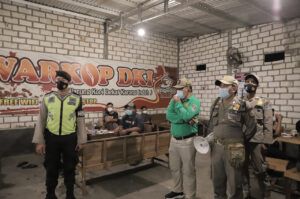 Petugas gabungan mengimbau kepada pengunjung kafe untuk mematuhi prokes saat operasi yustisi. (Foto: Humas Pemkab Tuban/Tugu Jatim)