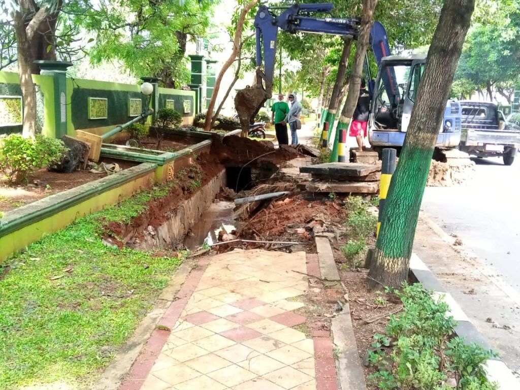 Perbaikan trotoar jalan dan saluran air dibantu alat berat di Jalan Pahlawan, Kelurahan Gedongombo, Kecamatan Semanding. (Foto: Rochim/Tugu Jatim)