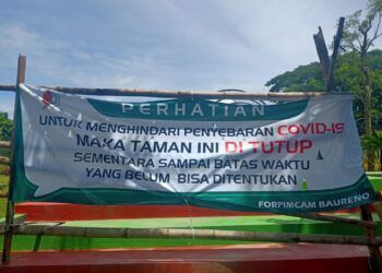 Tampak di depan Taman Gajah Bolong Bojonegoro dipasangi spanduk yang menandakan sementara tidak beroperasional. (Foto:Mila Arinda/Tugu Jatim)