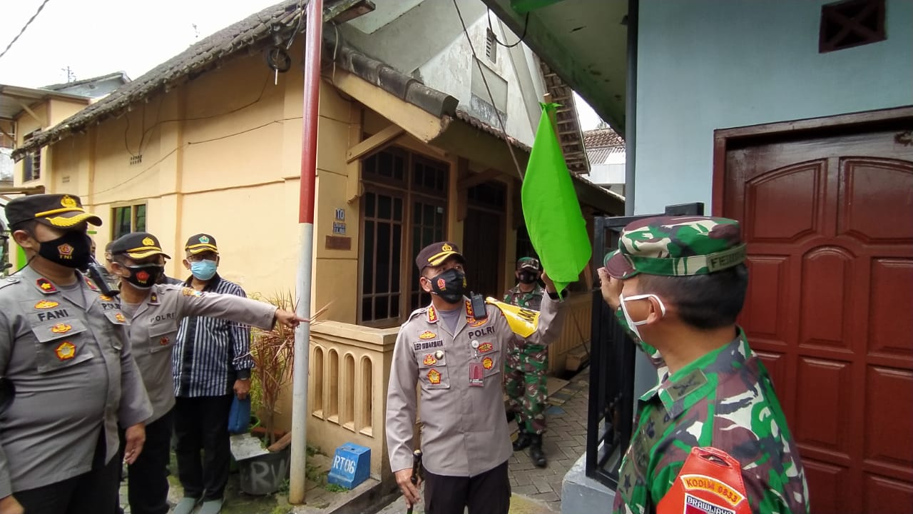 Kapolresta Malang Kota Kombes Pol Leonardus Simarmata menunjukkan bendera zonasi hijau di RW 1, Kelurahan Sukoharjo, Klojen, Kota Malang, Sabtu (13/02/2021). (Foto: Azmy/Tugu Jatim)
