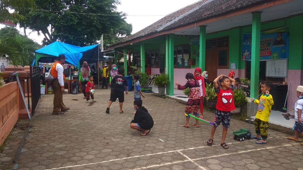 Anak-anak yang mengungsi karena bencana longsor sedang bermain di halaman SDN 3 Ngetos, Nganjuk. (Foto: Noe/Tugu Jatim)