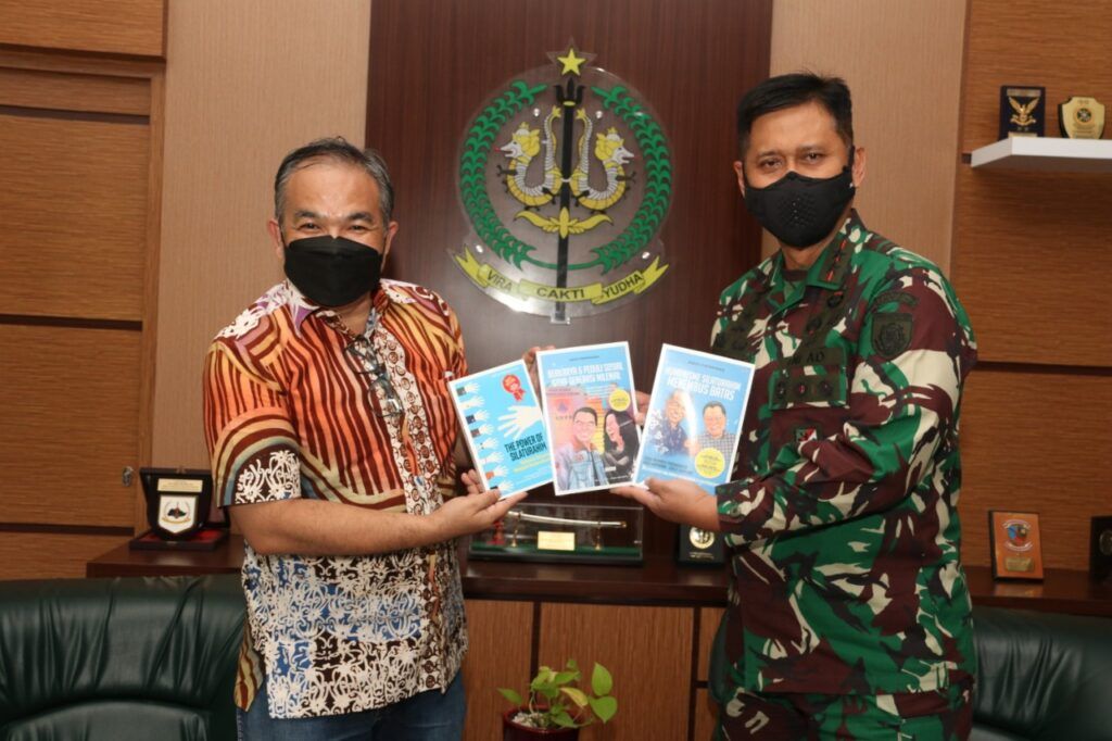 Panglima Divisi Infanteri (Pangdivif) 2/Vira Cakti Yudha Kostrad Mayjen TNI Tri Yuniarto diberi buku trilogi karya Pakar Komunikasi dan Motivasi Dr Aqua Dwipayana. (Foto: Dok/Tugu Jatim)