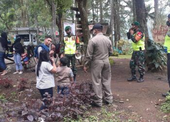 Babinsa Puspo, Pasuruan, patroli protokol kesehatan kepada pengunjung Tempat Wisata Red Flower. (Foto: Dok/Tugu Jatim)