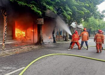 Petugas pemadam kebakaran saat memadamkan api di toko helm, dekat Stasiun Kota Baru Malang. (Foto: UPT Damkar Kota Malang/Tugu Jatim)