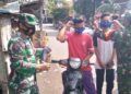 Anggota TNI dari Koramil Kraton Kodim 0819 Pasuruan bagikan masker ke masyrakat. (Foto: Dokumen)