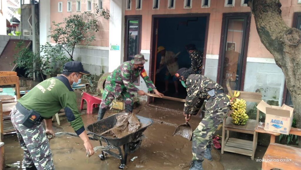 Personel TNI dari Kodim 0819 Pasuruan ikut membantu membersihkan lumpur di rumah warga. (Foto: Dokumen) tugu jatim