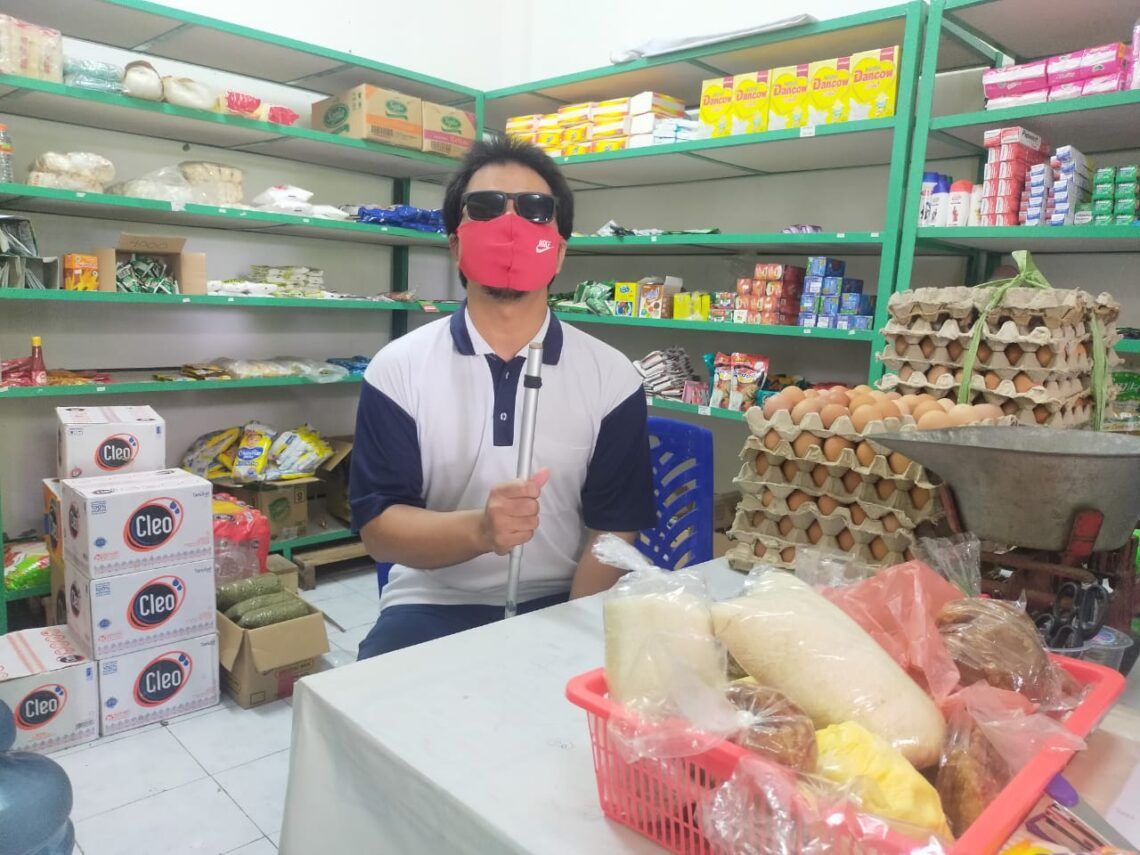 Mengenal Karjono, Penyandang Tunanetra yang Sukses Gagas Koperasi Syariah di Surabaya 1 Karjono sedang duduk di dalam koperasi Almuhajirin Siwalankerto Sejahtera di Rumah Susun (Rusun) Siwalankerto Surabaya. (Foto: Dokumen/Pemkot Surabaya)