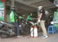 Driver ojol saat melakukan sterilisasi kendaraan di Posko J3K Kantor Gojek Malang. (Foto: Azmy/Tugu Malang/Tugu Jatim)