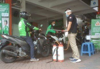 Driver ojol saat melakukan sterilisasi kendaraan di Posko J3K Kantor Gojek Malang. (Foto: Azmy/Tugu Malang/Tugu Jatim)