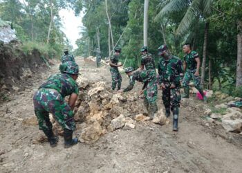 Anggota TNI dari Kodim 0801/Pacitan Jawa Timur yang turun membantu membangun jalan desa di Desa Widoro, Kecamatan Donorojo, Kabupaten Pacitan, Rabu (10/2/2021). (Foto: Dokumen/Kodim 0801 Pacitan) tugu jatim
