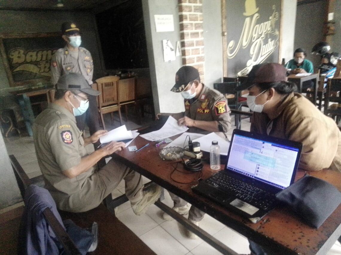 Petugas Gabungan Gelar Operasi Yustisi di Wonocolo, Surabaya 1 Tim Gabungan Polsek, Koramil, SATPOL-PP dan Kecamatan Wonocolo sedang Menjalankan Sidak di Beberapa Warung Kopi yang Berlokasi di Kecamatan Wonocolo. (Foto: Rangga Aji/Tugu Jatim)