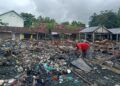 Fais, tukang rongsok yang mengambil seng bekas atap pasar yang dijual kepadanya. (Foto : Mila Arinda/Tugu Jatim)