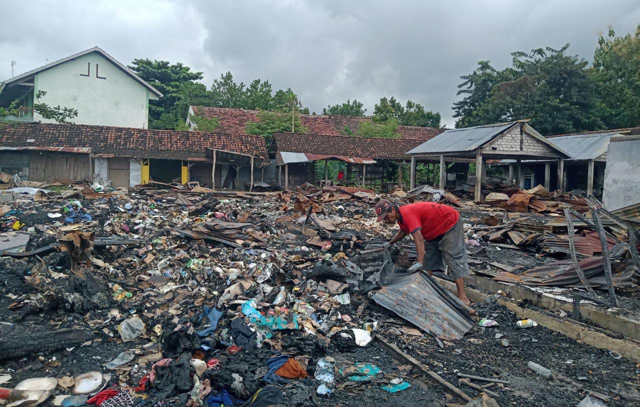 Fais, tukang rongsok yang mengambil seng bekas atap pasar yang dijual kepadanya. (Foto : Mila Arinda/Tugu Jatim)