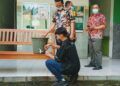 Ibrahim Khalilullah (siswa yang memakai baju hitam) dan Khoirul Muhlisin (siswa yang memakai baju motif kotak-kotak) sedang mencoba alat cuci tangan sensor. (Rangga Aji/Tugu Jatim) SMK YPM 11 Wonoayu, alat cuci tangan otomatis sensor elektronik