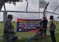 Sejumlah warga di Kecamatan Jenu, Kabupaten Tuban tampak bersama-sama memasang banner atau spanduk yang melarang sales-marketing masuk wilayah desa mereka. (Foto: Moch Abdurrochim)