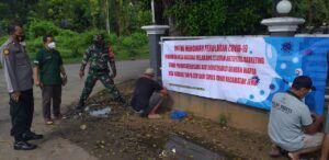Sejumlah warga di Kecamatan Jenu, Kabupaten Tuban tampak bersama-sama memasang banner atau spanduk yang melarang sales-marketing masuk wilayah desa mereka. (Foto: Moch Abdurrochim)