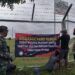 Sejumlah warga di Kecamatan Jenu, Kabupaten Tuban tampak bersama-sama memasang banner atau spanduk yang melarang sales-marketing masuk wilayah desa mereka. (Foto: Moch Abdurrochim)